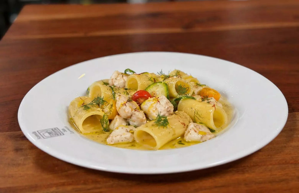 Paccheri mit Wolfsbarsch, Dorade, Zucchini und Kirschtomaten in cremiger Wermut-Safran-Sauce