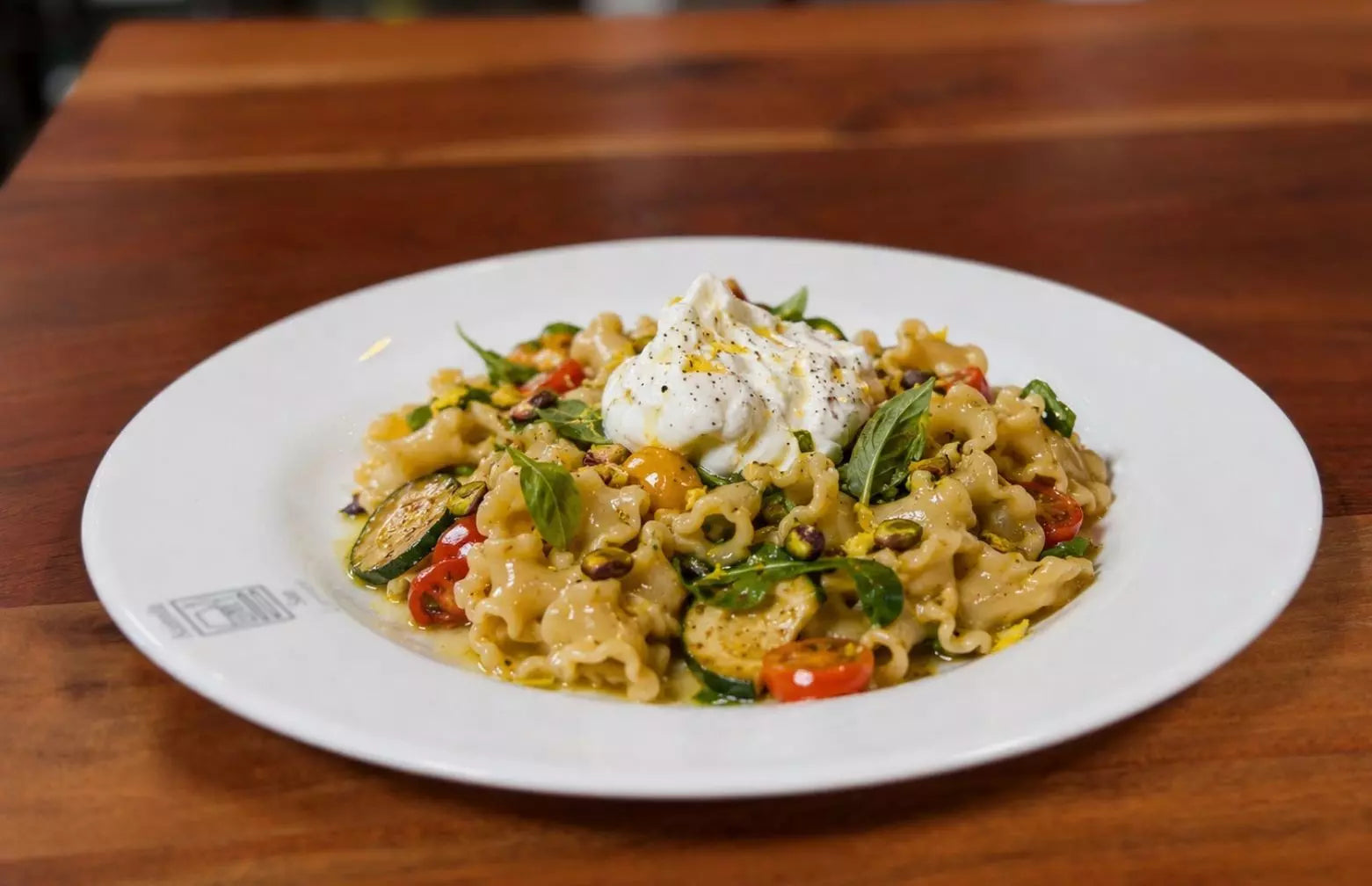 Pasta Gigli mit gebratener Zucchini, Kirschtomaten, Burrata di Bufala, Pistazien und Basilikum