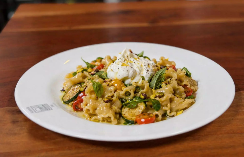 Pasta Gigli mit gebratener Zucchini, Kirschtomaten, Burrata di Bufala, Pistazien und Basilikum